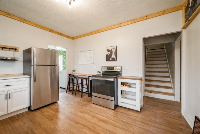 17492 460th Ln, Waterville, MN 56096 - kitchen featuring light wood-style flooring, stainless steel appliances, white cabinets, a textured ceiling, and light countertops