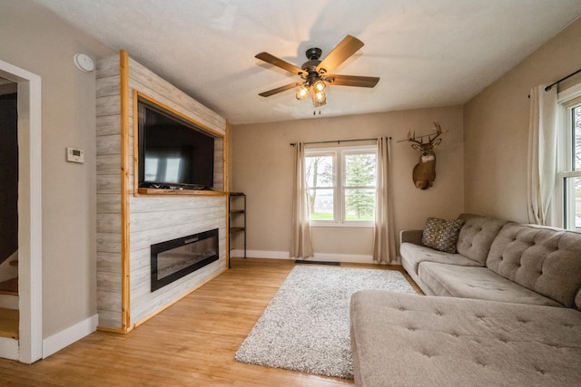 17492 460th Ln, Waterville, MN 56096 - living area with a large fireplace, baseboards, wood finished floors, and a ceiling fan
