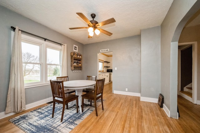 17492 460th Ln, Waterville, MN 56096 - dining space featuring light wood finished floors, a ceiling fan, stairway, baseboards, and arched walkways