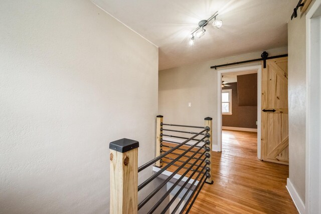 17492 460th Ln, Waterville, MN 56096 - corridor featuring baseboards, light wood finished floors, an upstairs landing, and a barn door