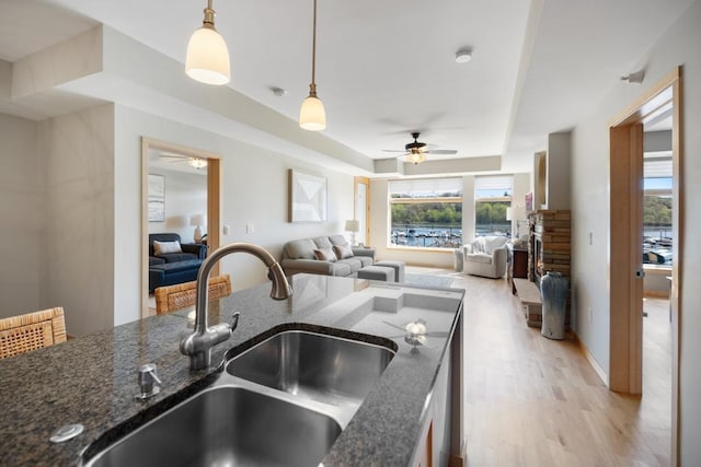kitchen with ceiling fan, a sink, and open floor plan