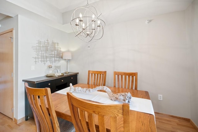 dining room with an inviting chandelier, baseboards, and light wood-style floors