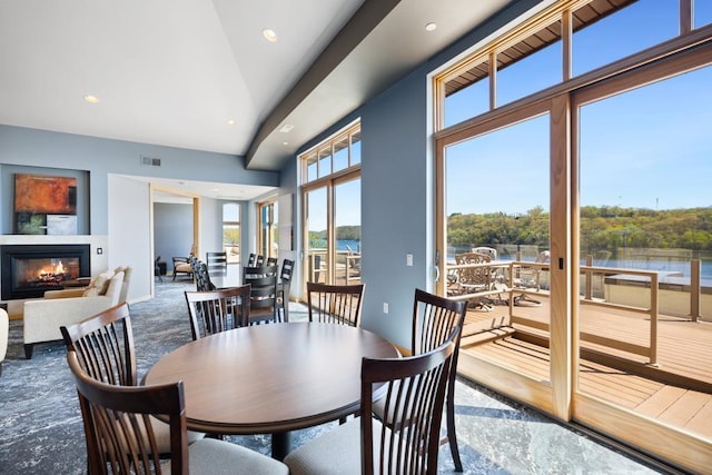 dining area with recessed lighting, a water view, a glass covered fireplace, and visible vents