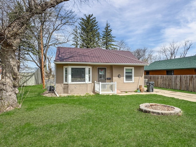 exterior space with metal roof, a yard, central AC, and fence