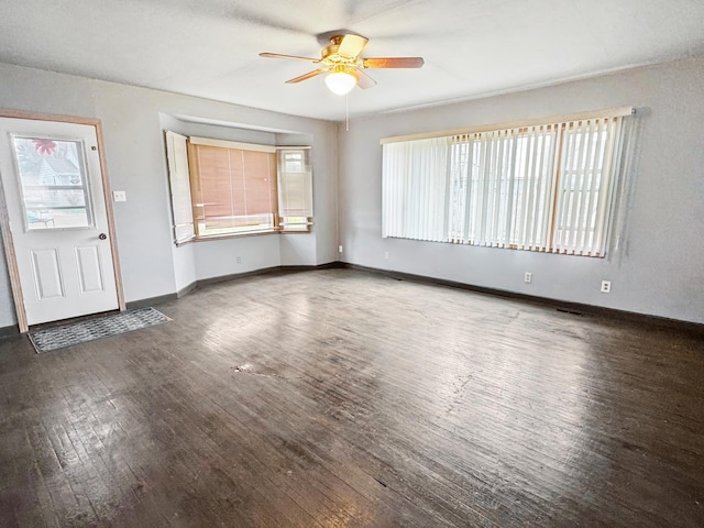 unfurnished living room featuring ceiling fan, baseboards, wood finished floors, and plenty of natural light