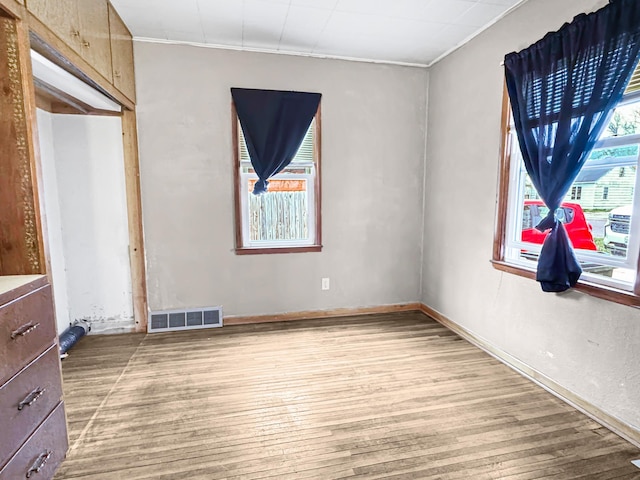 unfurnished bedroom with crown molding, visible vents, baseboards, and light wood-type flooring