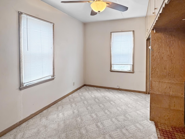 spare room featuring a ceiling fan, baseboards, and carpet floors