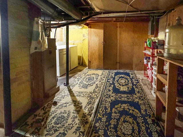 unfinished below grade area with washing machine and clothes dryer