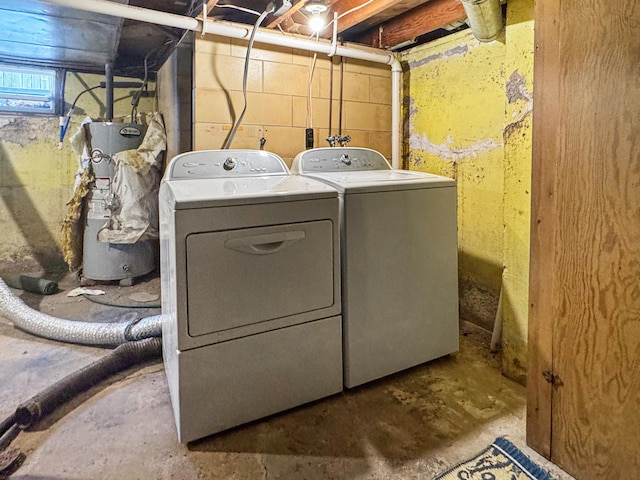 washroom featuring water heater, independent washer and dryer, and laundry area
