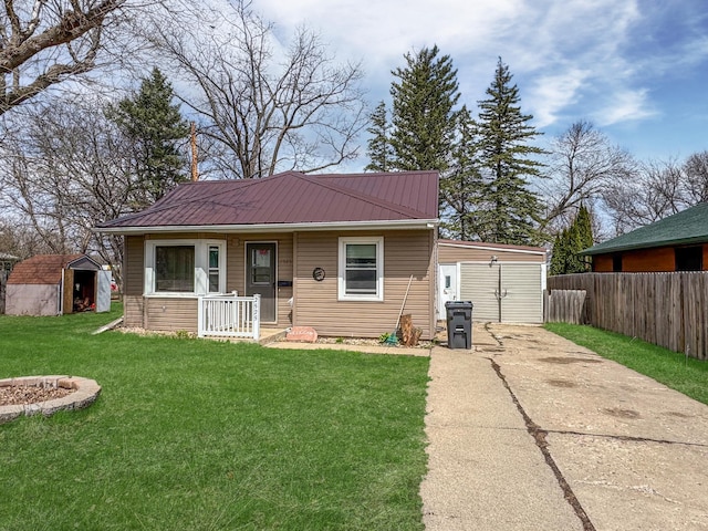 bungalow with metal roof, a shed, covered porch, a front yard, and fence