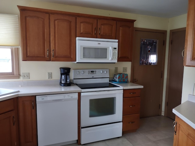 122 10th St, Madison, MN 56256 - kitchen with white appliances, light countertops, and brown cabinets