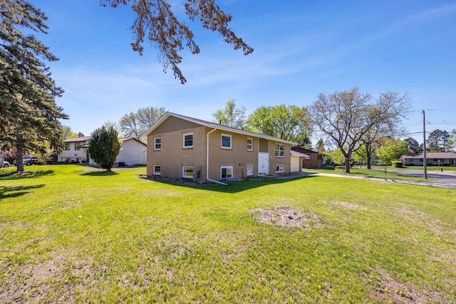 8040 Xenia Ave N, Brooklyn Park, MN 55443 - view of home's exterior featuring a yard, an attached garage, and brick siding