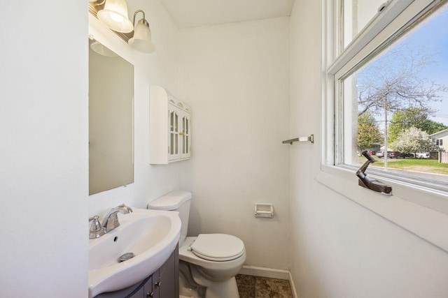 8040 Xenia Ave N, Brooklyn Park, MN 55443 - half bathroom featuring toilet, baseboards, and vanity