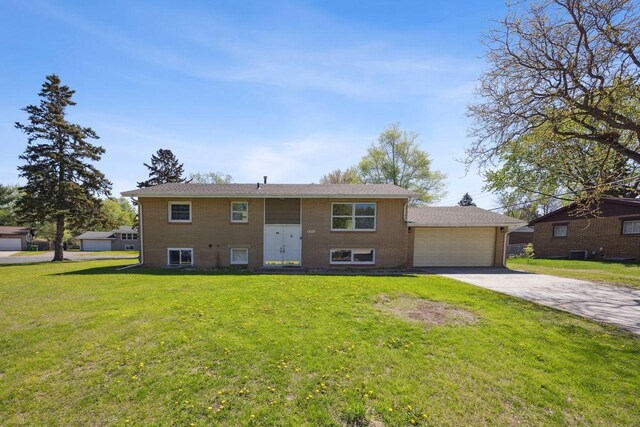 8040 Xenia Ave N, Brooklyn Park, MN 55443 - raised ranch featuring concrete driveway, a front lawn, brick siding, a garage, and central AC unit