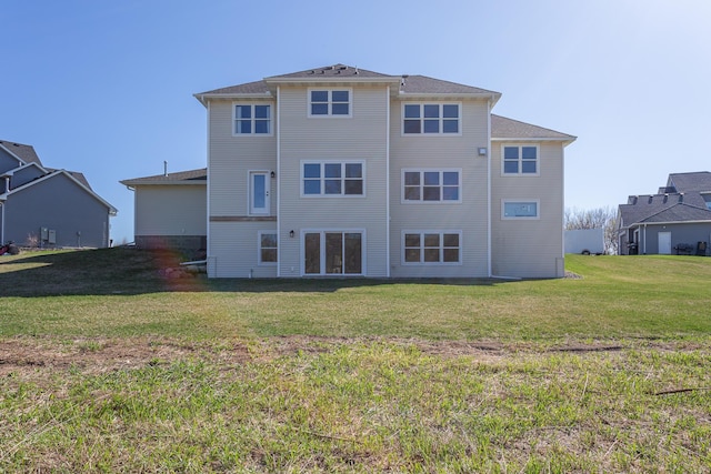 rear view of property featuring a lawn