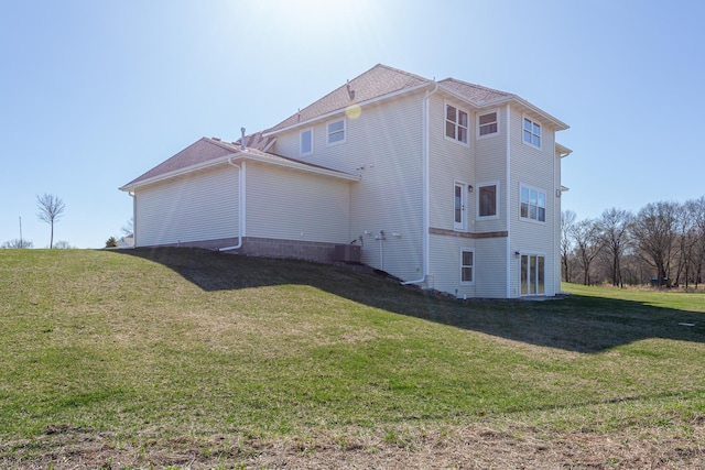 view of property exterior with a lawn and central AC unit
