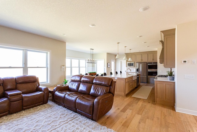 living area featuring light wood-style flooring and a chandelier