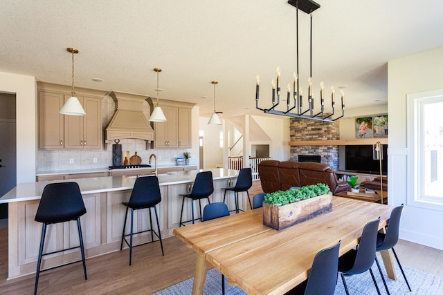 dining space featuring a healthy amount of sunlight, light wood finished floors, and a fireplace