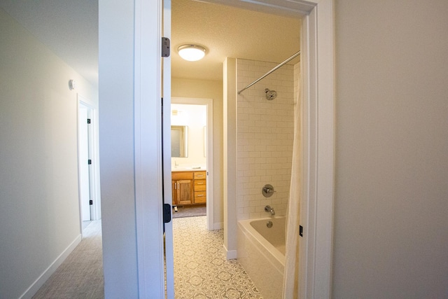 bathroom with vanity, baseboards, and shower / bath combo with shower curtain