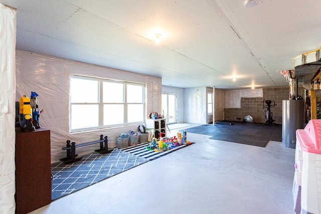 below grade area featuring concrete block wall and water heater