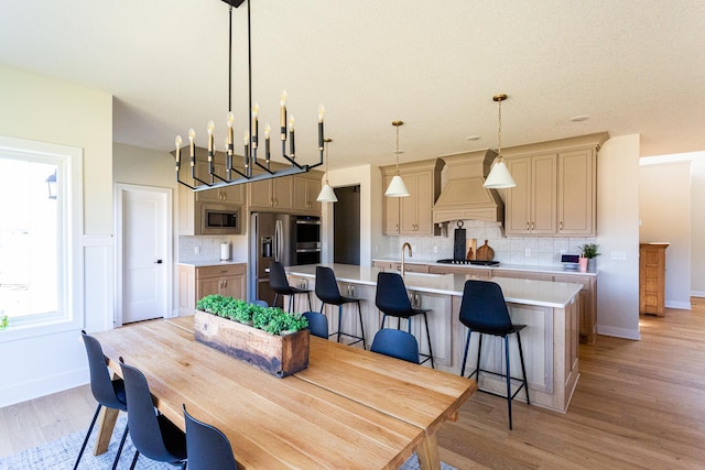 dining space featuring baseboards and light wood-style flooring