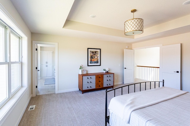bedroom with visible vents, baseboards, multiple windows, and light carpet