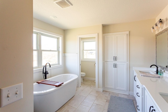 4465 167th Ave NW, Andover, MN 55304 - full bath with a freestanding tub, double vanity, toilet, and a textured ceiling