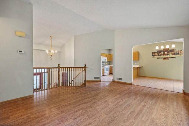 1312 Widgeon Way, Buffalo, MN 55313 - unfurnished room with a chandelier, vaulted ceiling, and light wood finished floors
