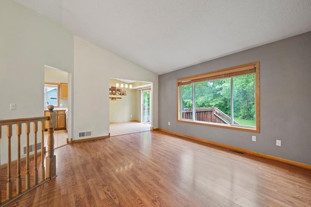 1312 Widgeon Way, Buffalo, MN 55313 - unfurnished room featuring wood finished floors, a chandelier, and lofted ceiling