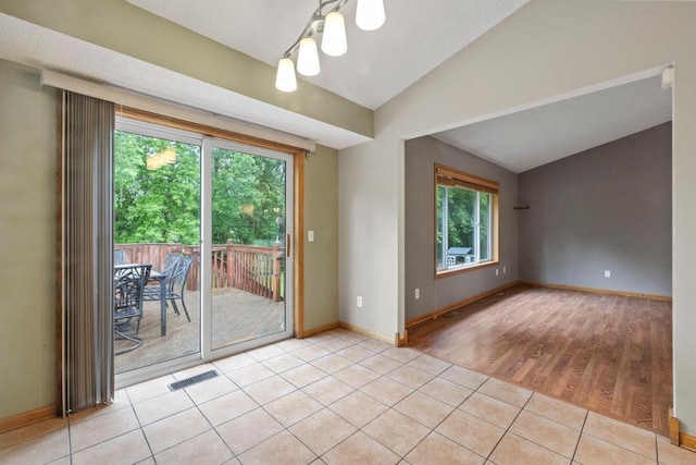 1312 Widgeon Way, Buffalo, MN 55313 - unfurnished room featuring lofted ceiling, light tile patterned floors, and a chandelier