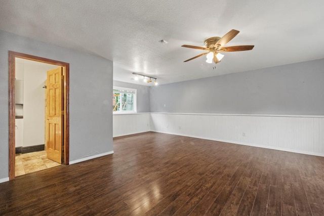 1312 Widgeon Way, Buffalo, MN 55313 - unfurnished room with wood finished floors, ceiling fan, a wainscoted wall, and a textured ceiling