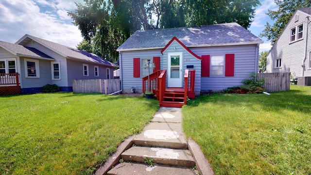 bungalow with roof with shingles, fence, and a front yard