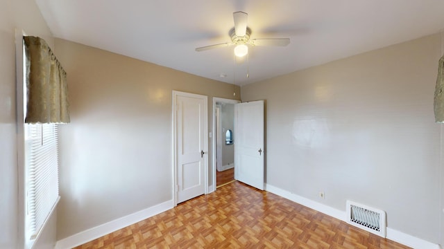 unfurnished bedroom featuring baseboards, ceiling fan, and visible vents