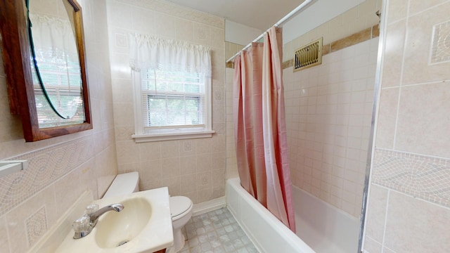 full bath with vanity, tile walls, shower / bath combo, and toilet