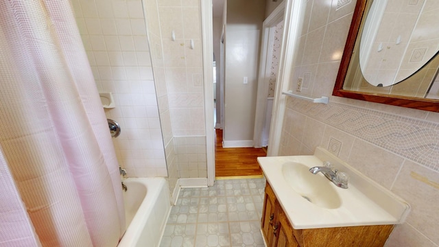 bathroom featuring baseboards, shower / bath combo, and vanity