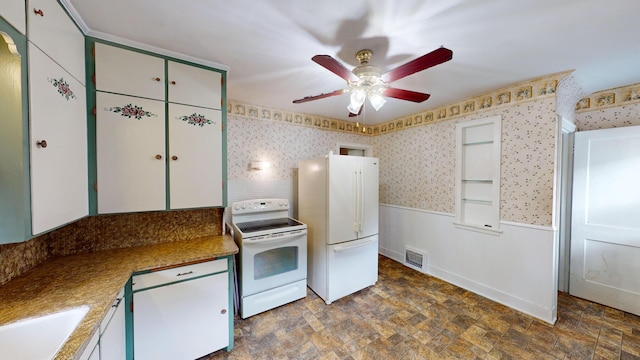 kitchen featuring wainscoting, a sink, white appliances, a ceiling fan, and visible vents