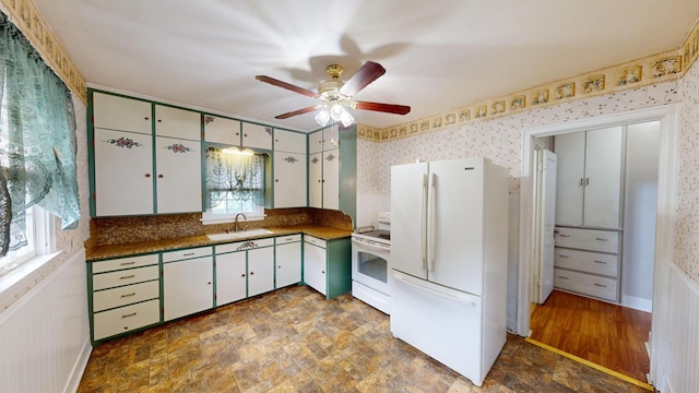 kitchen featuring dark countertops, ceiling fan, wallpapered walls, and white appliances
