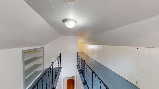 hall featuring vaulted ceiling and built in shelves
