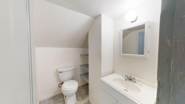 half bath with vanity, toilet, and lofted ceiling