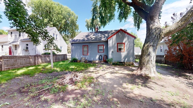 back of house featuring fence and a chimney