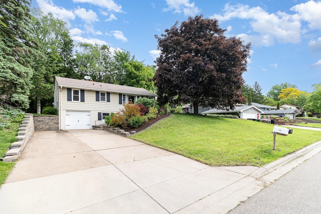 423 Eldridge Ave W, Roseville, MN 55113 - view of front facade featuring concrete driveway, an attached garage, and a front yard