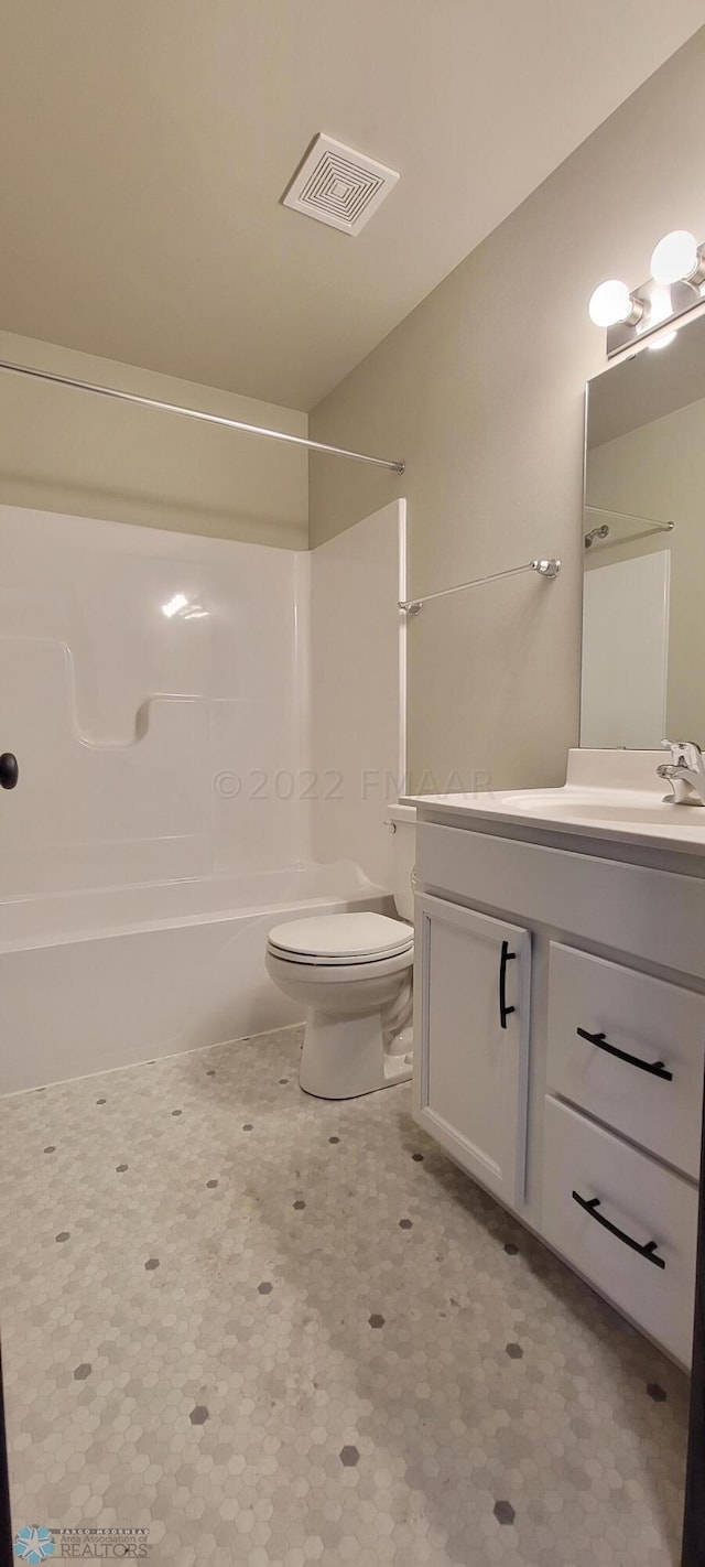 bathroom with visible vents, toilet,  shower combination, and vanity