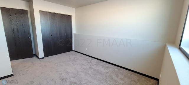 unfurnished bedroom with a closet and carpet