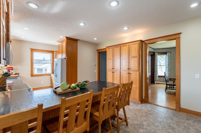 dining area featuring recessed lighting, a textured ceiling, and baseboards