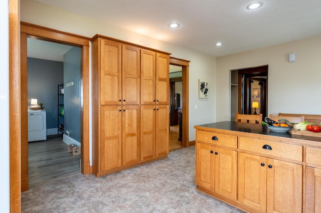 kitchen featuring washer / clothes dryer, recessed lighting, baseboards, and dark countertops