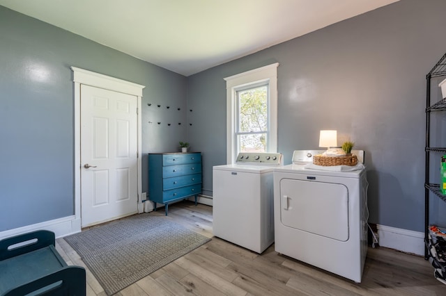 laundry area featuring washing machine and dryer, light wood-type flooring, a baseboard heating unit, and baseboards