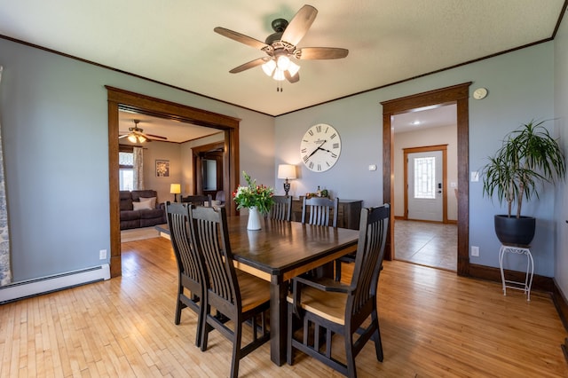 dining space featuring ceiling fan, plenty of natural light, baseboard heating, crown molding, and light wood finished floors