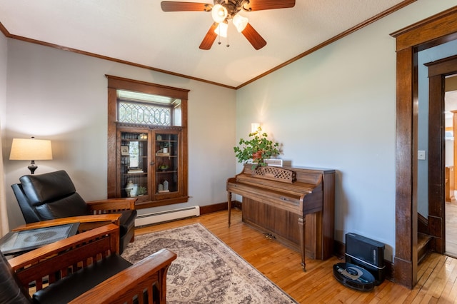 living area featuring baseboard heating, light wood finished floors, a ceiling fan, ornamental molding, and a desk