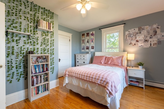 bedroom with hardwood / wood-style floors, baseboards, a baseboard radiator, and ceiling fan