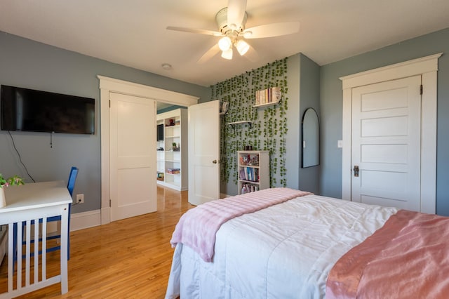 bedroom featuring light wood-style floors, baseboards, and a ceiling fan